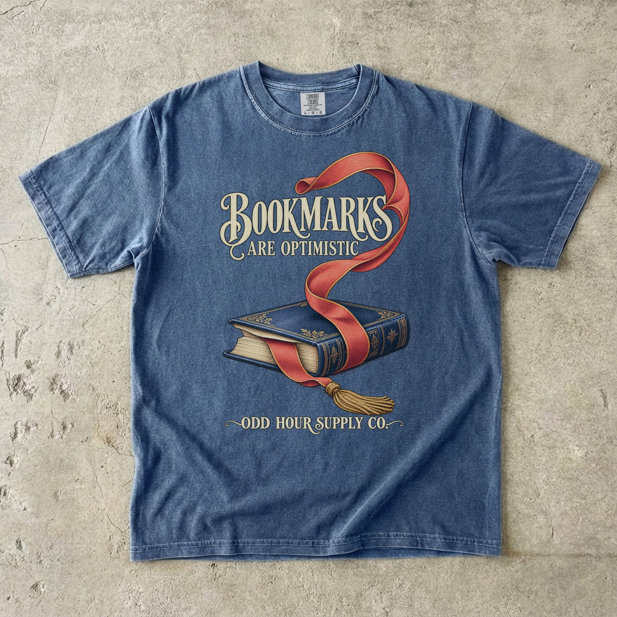 T-Shirt in Denim mit blauem Buch, rotem Lesezeichen und BOOKMARKS ARE OPTIMISTIC von Odd Hour Supply Co.