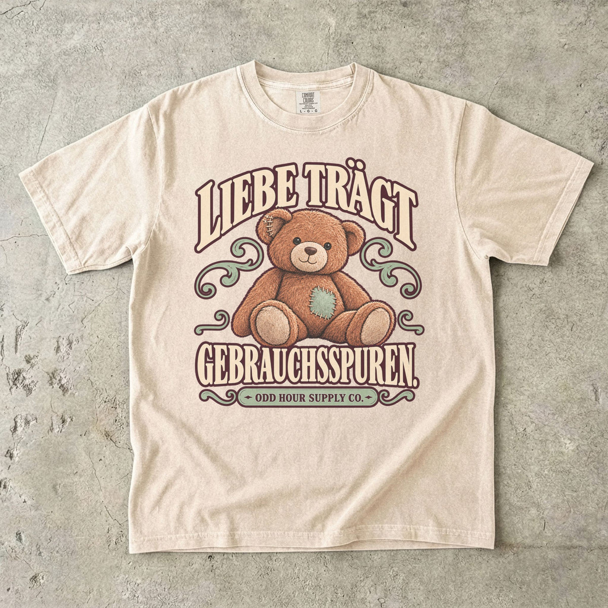 Comfort Colors 1717 T-Shirt in Ivory mit dem Motiv „Liebe trägt Gebrauchsspuren“ mit Teddybär, Vorderansicht