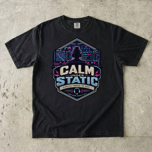 Comfort Colors 1717 T-Shirt in Black mit Calm Under Static Frontmotiv, Leitstellenperson am Headset, Monitorwand und Cyan-Magenta-Akzenten.