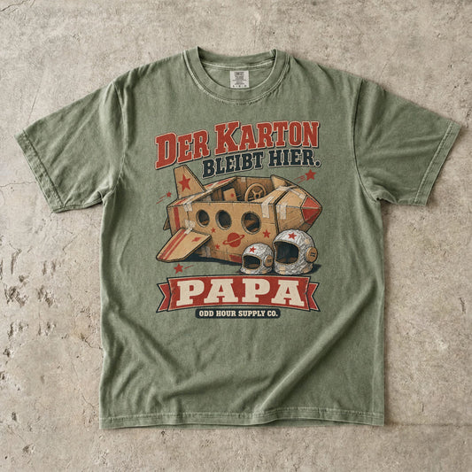 Comfort Colors 1717 T-Shirt in Hemp: Raumschiff aus braunen Kartons mit roten Sternen und zwei silbernen Helmen, dazu DER KARTON BLEIBT HIER., PAPA und ODD HOUR SUPPLY CO.