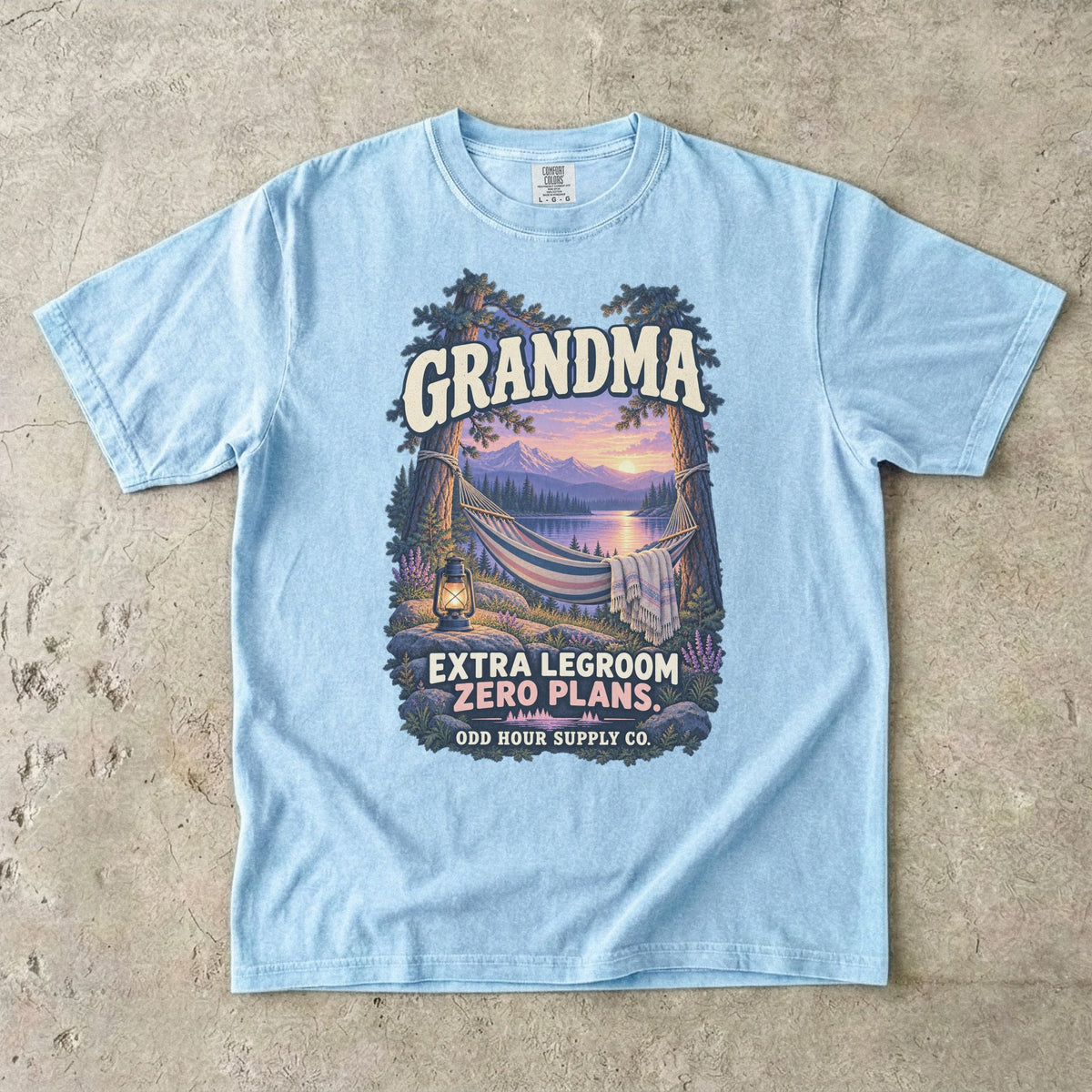 Comfort Colors 1717 T-Shirt in Chambray mit Hängematte zwischen Bäumen, See, Bergen, Laterne und der Aufschrift Grandma Extra Legroom Zero Plans.