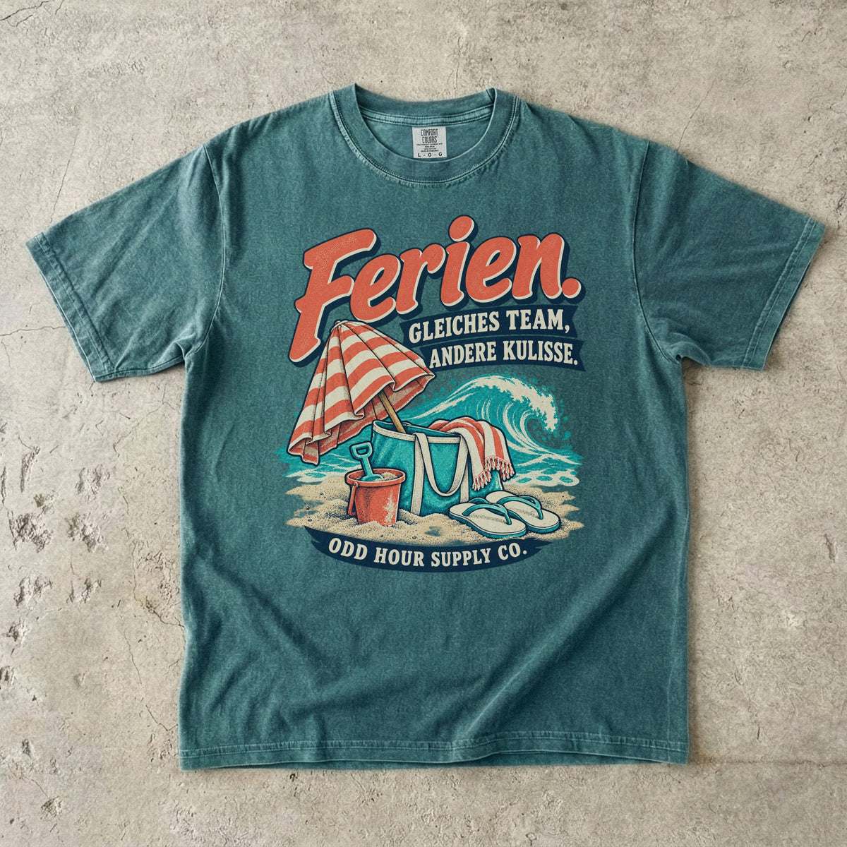Comfort Colors 1717 T-Shirt in Blue Spruce mit dem Motiv „Ferien. Gleiches Team, andere Kulisse“ mit Strandmotiv, Vorderansicht