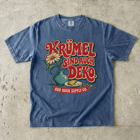 Comfort Colors 1717 T-Shirt in Denim mit dem Motiv „Krümel sind auch Deko“ mit Blumenvase, Vorderansicht