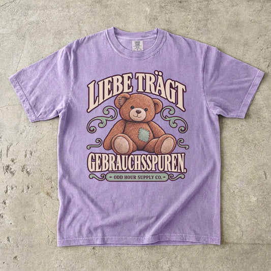 Comfort Colors 1717 T-Shirt in Orchid mit dem Motiv „Liebe trägt Gebrauchsspuren“ mit Teddybär, Vorderansicht