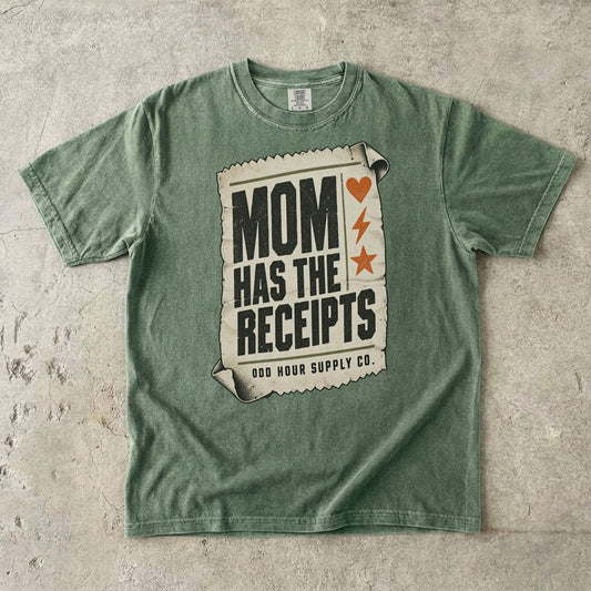Comfort Colors 1717 T-Shirt in Moss mit cremefarbenem Kassenbon, schwarzer Mom Has the Receipts-Schrift und orangefarbenem Herz, Blitz und Stern.