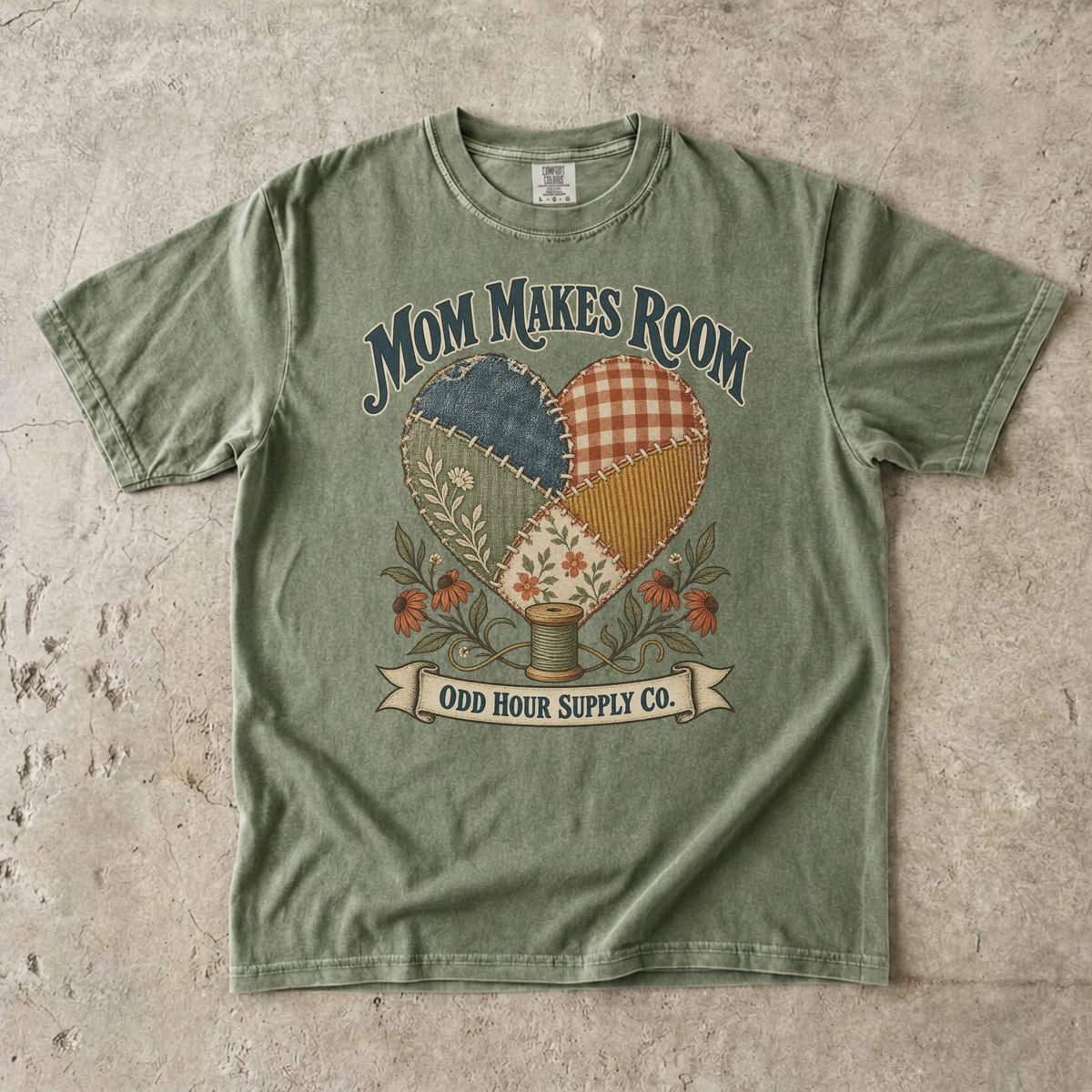 Comfort Colors 1717 T-Shirt in Hemp mit Patchwork-Herz aus gemusterten Stoffstücken, Blumen, Garnrolle und Mom Makes Room-Schrift.
