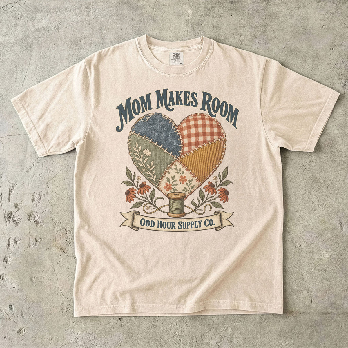 Comfort Colors 1717 T-Shirt in Ivory mit Patchwork-Herz aus gemusterten Stoffstücken, Blumen, Garnrolle und Mom Makes Room-Schrift.