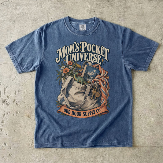 Comfort Colors 1717 T-Shirt in Denim mit gefüllter Stofftasche, Blumen, Buch, Spielzeugdinosaurier, Schlüsseln und Mom’s Pocket Universe-Schrift.