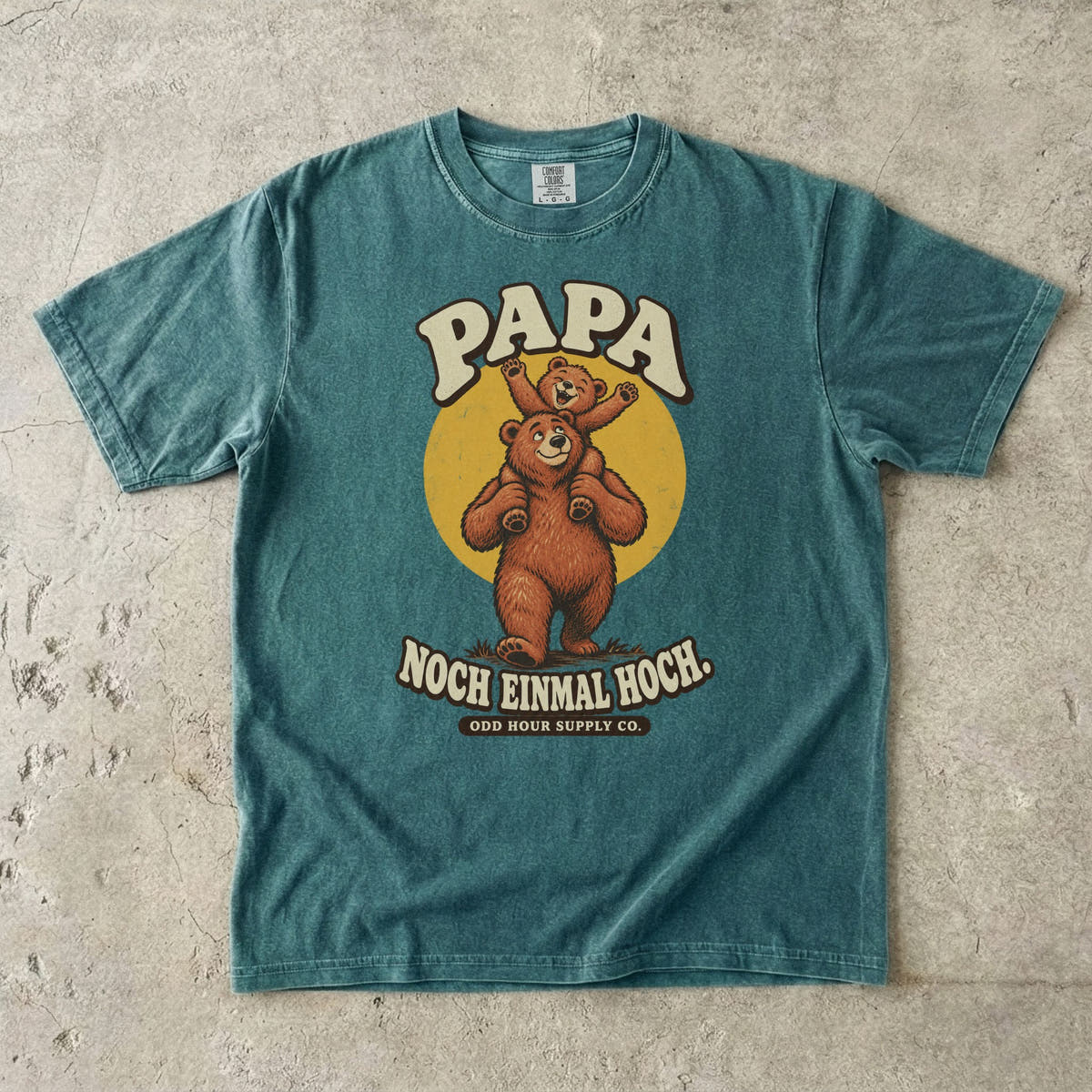 Comfort Colors 1717 T-Shirt in Blue Spruce: Großer Bär mit einem winkenden Bärenkind auf den Schultern vor einem gelben Kreis, dazu PAPA, NOCH EINMAL HOCH. und ODD HOUR SUPPLY CO.