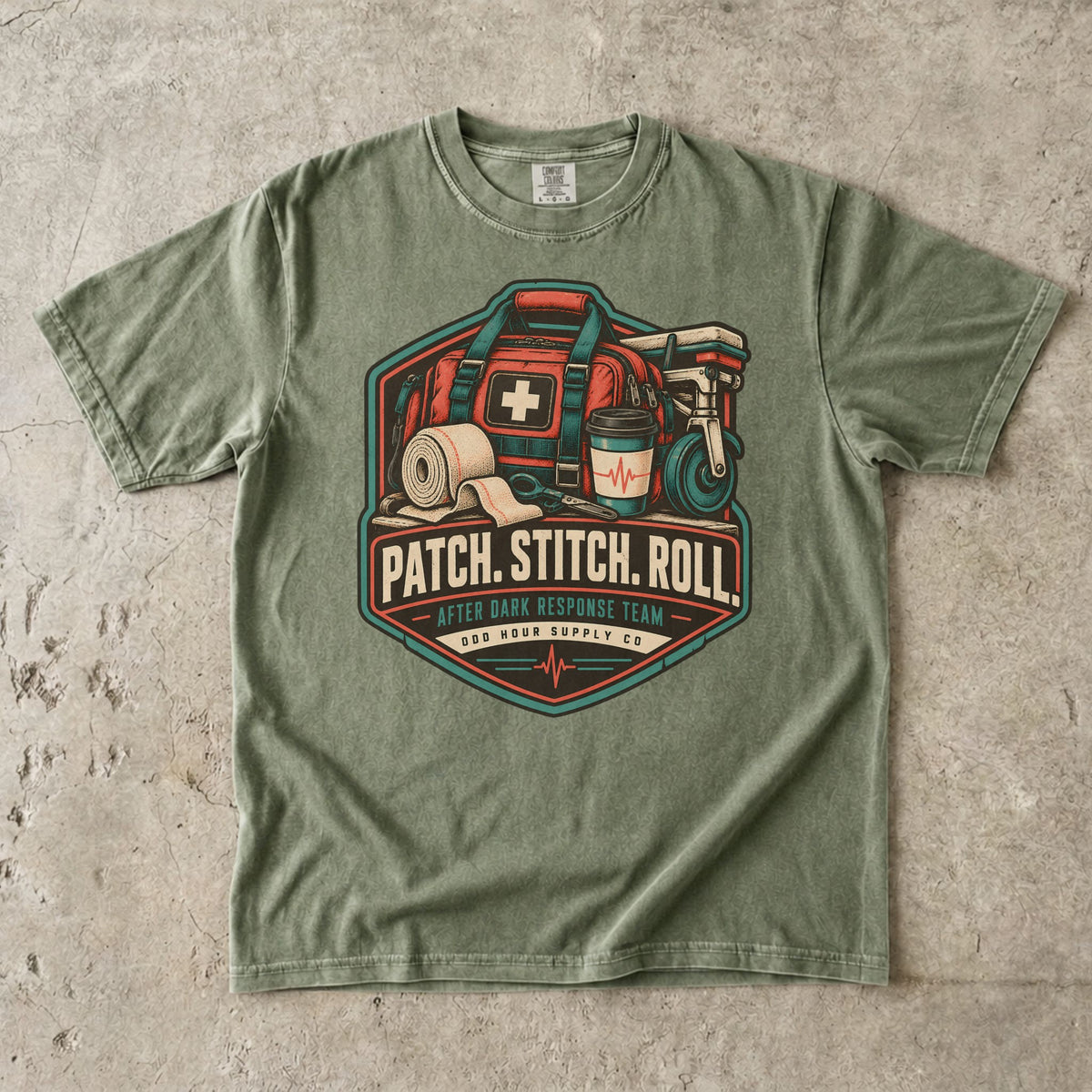 Comfort Colors 1717 T-Shirt in Hemp mit Patch Stitch Roll Badge, korallfarbener Notfalltasche, Verbänden, Kaffeebecher und Petrol-Akzenten.