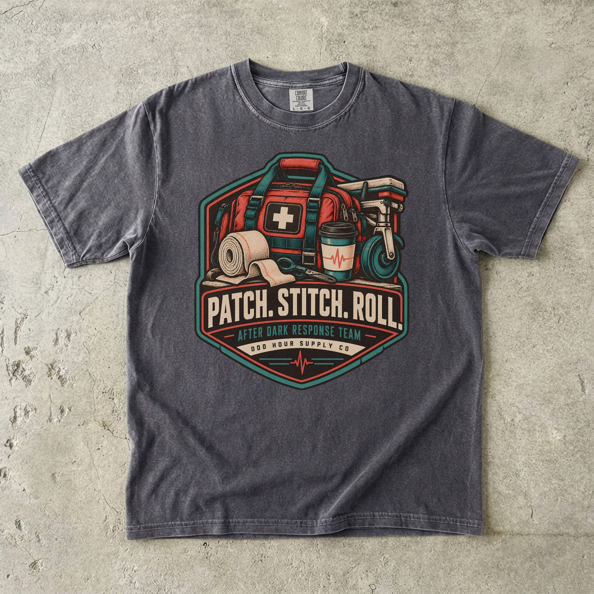 Comfort Colors 1717 T-Shirt in Pepper mit Patch Stitch Roll Badge, korallfarbener Notfalltasche, Verbänden, Kaffeebecher und Petrol-Akzenten.