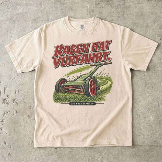 Comfort Colors 1717 T-Shirt in Ivory: Grüner Handrasenmäher auf einer Rasenfläche, darüber RASEN HAT VORFAHRT. in Rot, darunter ODD HOUR SUPPLY CO.