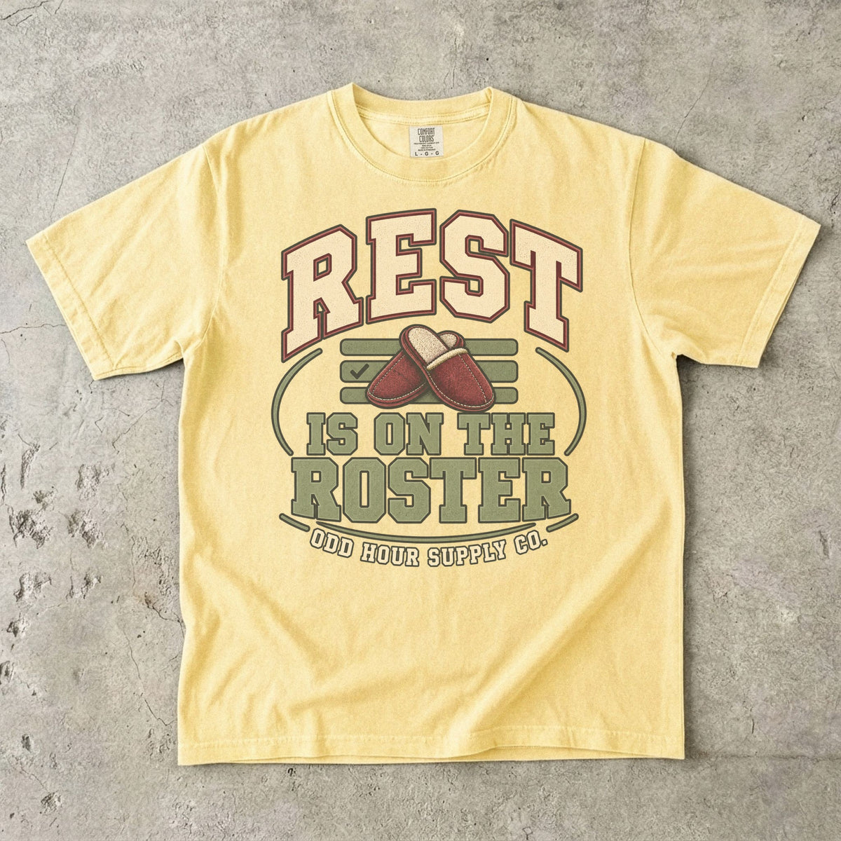 T-Shirt in Butter mit REST IS ON THE ROSTER, roten Hausschuhen und Odd Hour Supply Co. im College-Look.