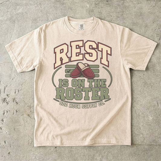 T-Shirt in Ivory mit REST IS ON THE ROSTER, roten Hausschuhen und Odd Hour Supply Co. im College-Look.