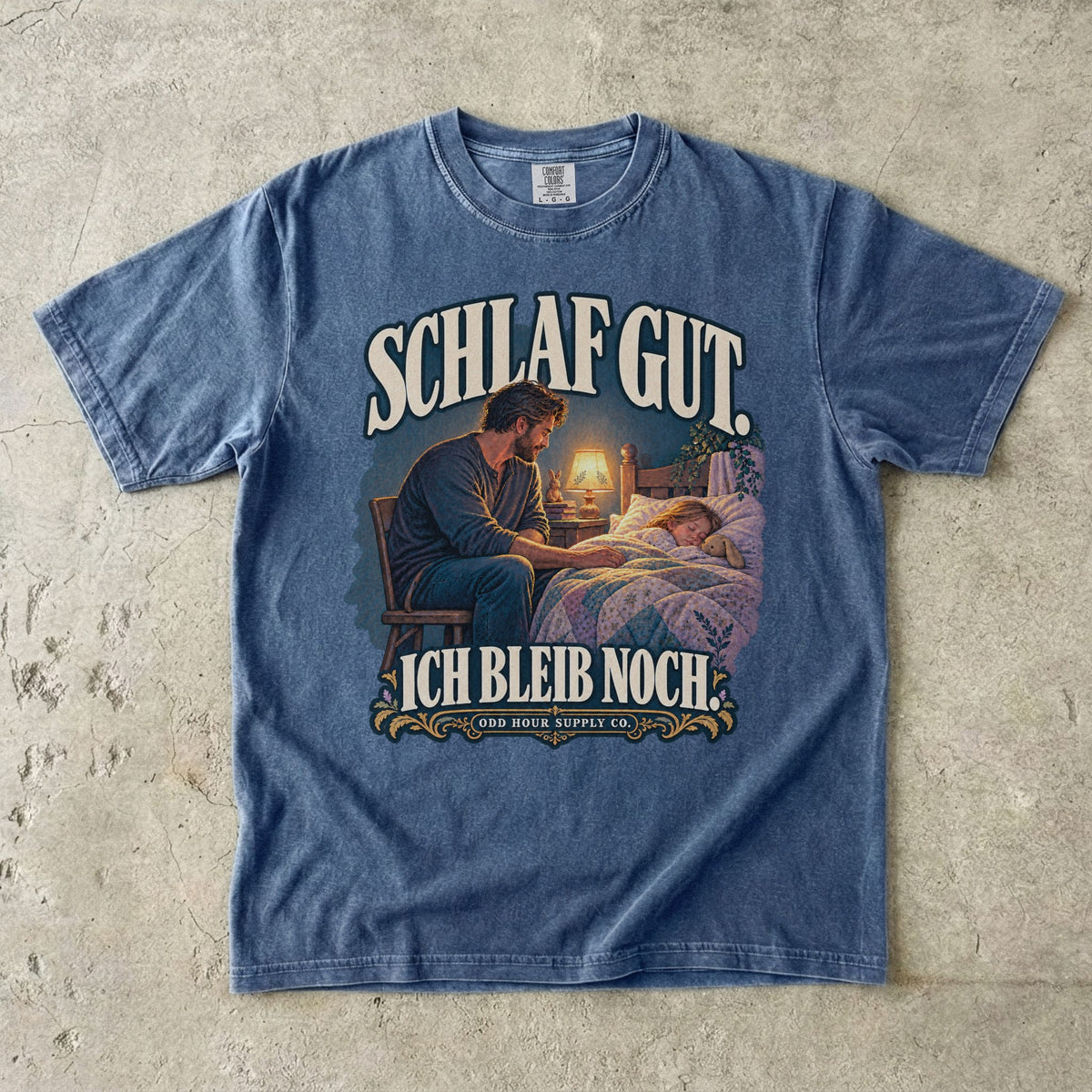 Comfort Colors 1717 T-Shirt in Denim: Vater sitzt neben einem schlafenden Kind am Bett im warmen Licht einer Lampe, dazu SCHLAF GUT. ICH BLEIB NOCH. und ODD HOUR SUPPLY CO.