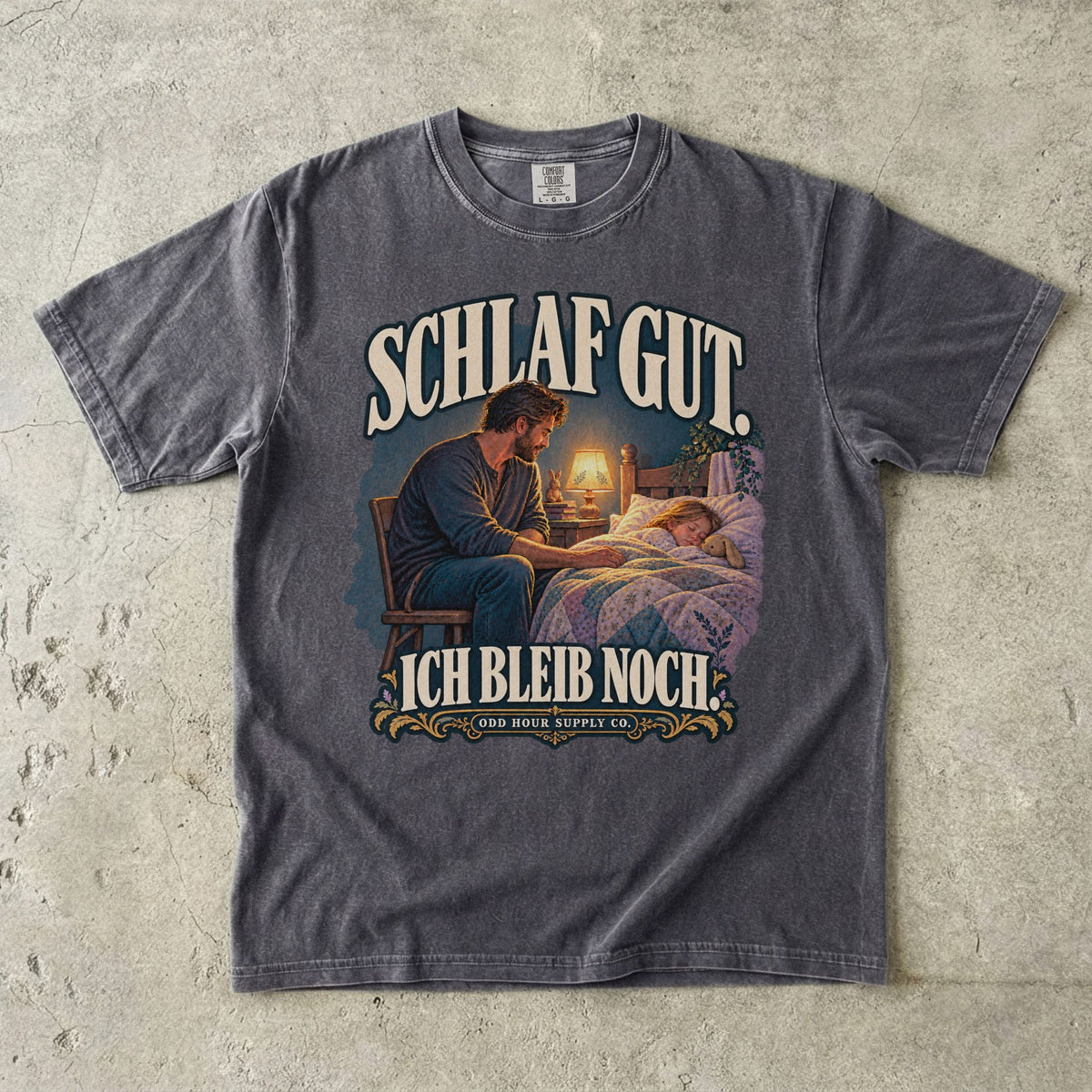 Comfort Colors 1717 T-Shirt in Pepper: Vater sitzt neben einem schlafenden Kind am Bett im warmen Licht einer Lampe, dazu SCHLAF GUT. ICH BLEIB NOCH. und ODD HOUR SUPPLY CO.