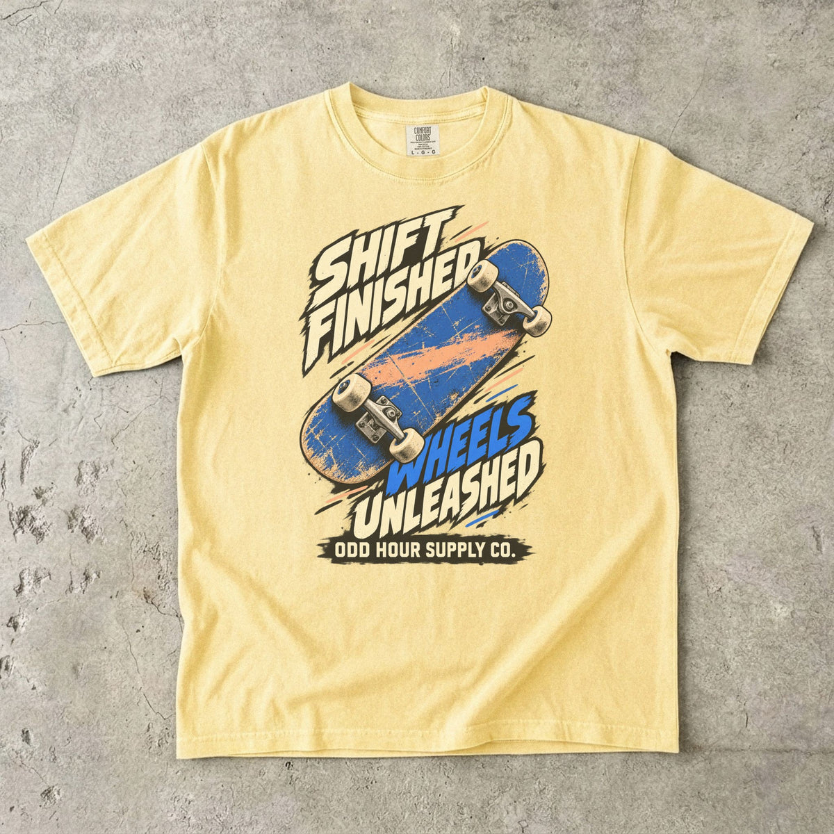 T-Shirt in Butter mit blauem Skateboard und SHIFT FINISHED WHEELS UNLEASHED von Odd Hour Supply Co.
