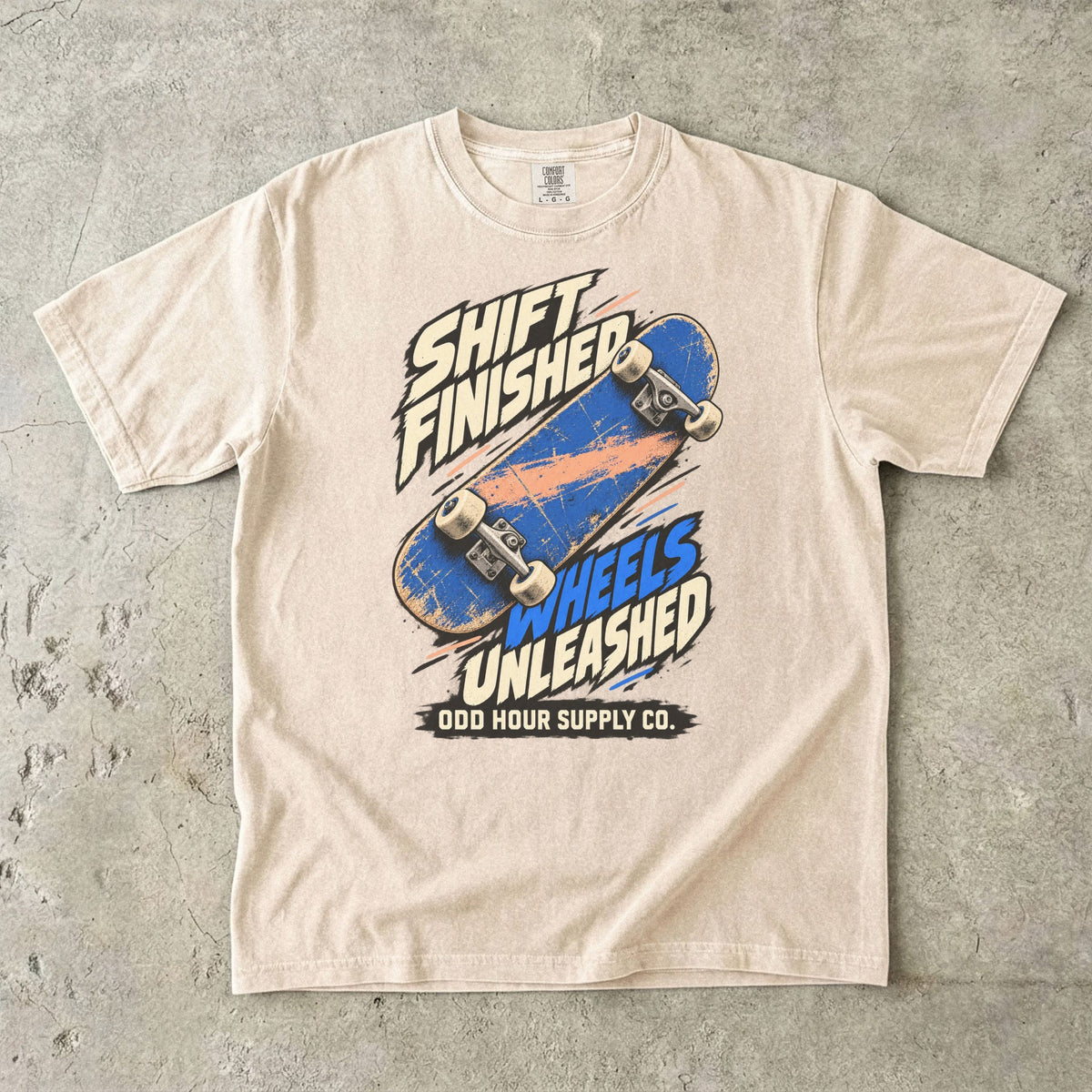 T-Shirt in Ivory mit blauem Skateboard und SHIFT FINISHED WHEELS UNLEASHED von Odd Hour Supply Co.