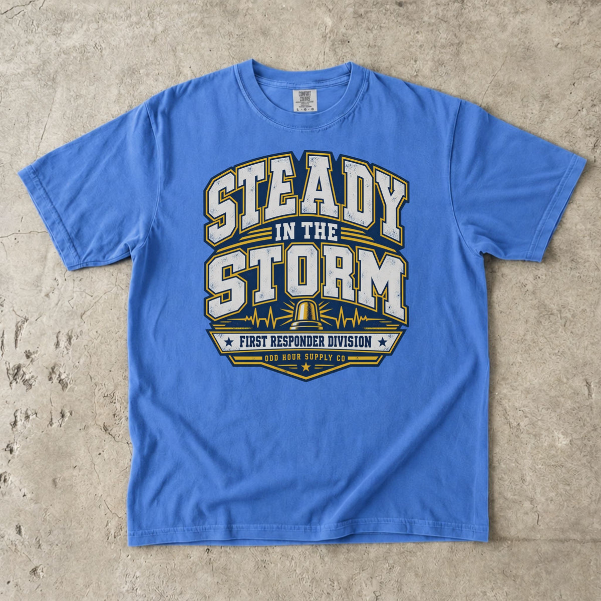 Comfort Colors 1717 T-Shirt in Flo Blue mit Steady in the Storm College-Motiv, gelber Rundumleuchte, Pulslinien und First Responder Division Schriftzug.