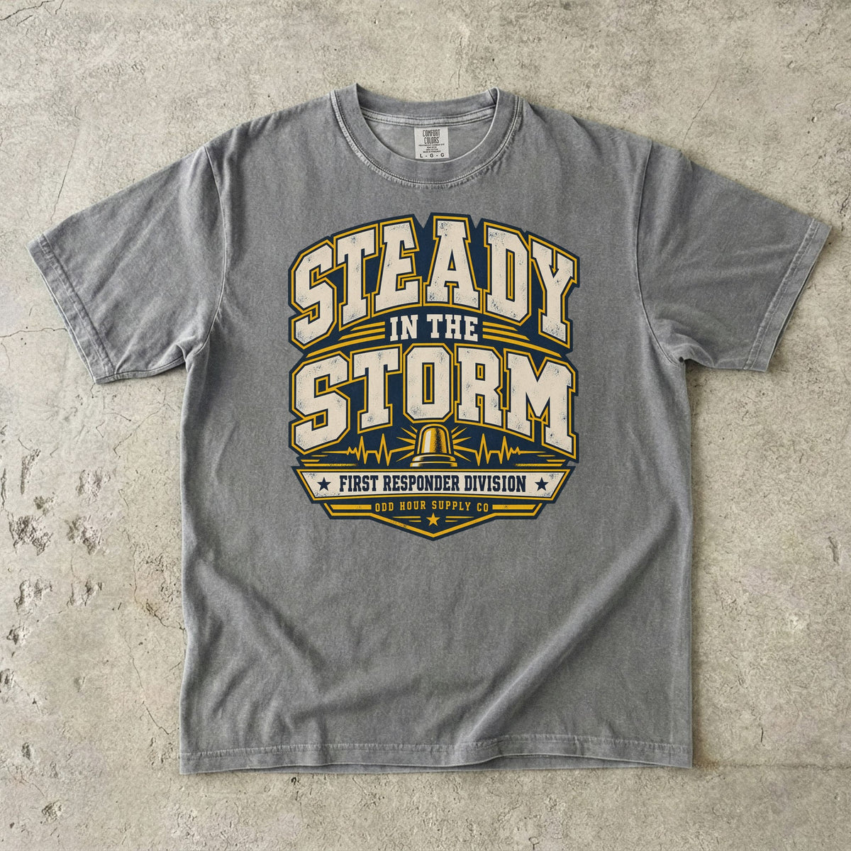 Comfort Colors 1717 T-Shirt in Granite mit Steady in the Storm College-Motiv, gelber Rundumleuchte, Pulslinien und First Responder Division Schriftzug.