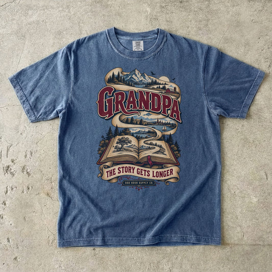 Denim-T-Shirt mit GRANDPA THE STORY GETS LONGER, offenem Buch und Landschaftsband von Odd Hour Supply Co.