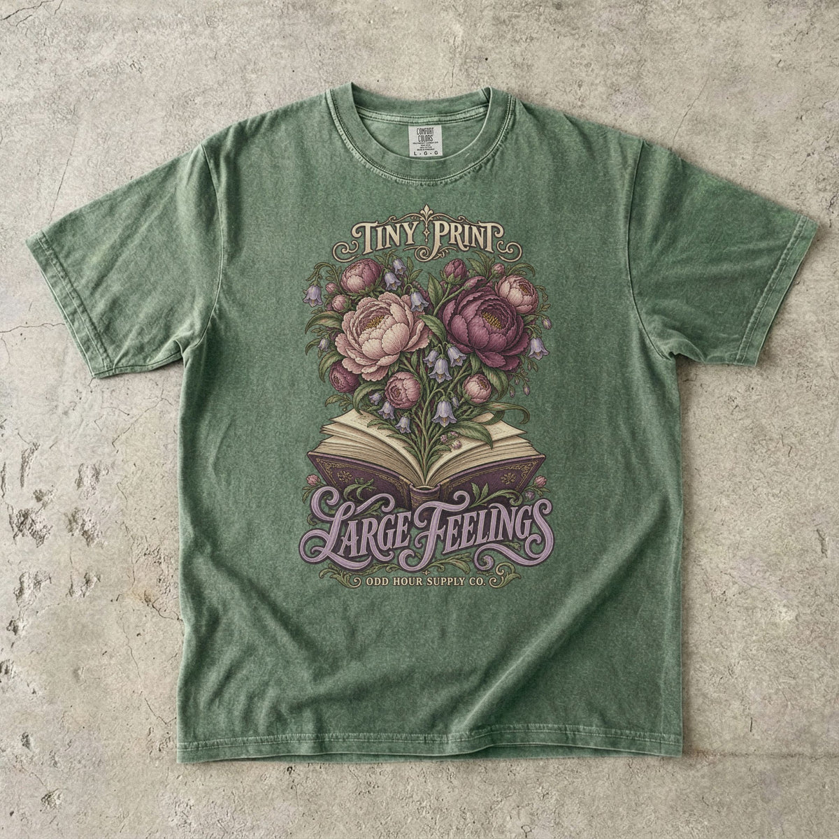 T-Shirt in Moss mit Blüten aus einem offenen Buch und TINY PRINT LARGE FEELINGS von Odd Hour Supply Co.