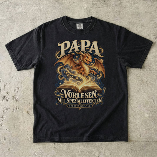 Comfort Colors 1717 T-Shirt in Black: Goldener Drache über einem offenen Buch mit Sternen und geschwungenen Linien, dazu PAPA, VORLESEN MIT SPEZIALEFFEKTEN. und ODD HOUR SUPPLY CO.