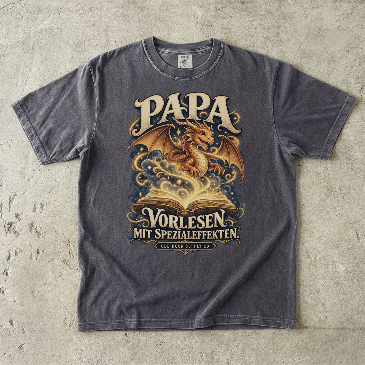 Comfort Colors 1717 T-Shirt in Pepper: Goldener Drache über einem offenen Buch mit Sternen und geschwungenen Linien, dazu PAPA, VORLESEN MIT SPEZIALEFFEKTEN. und ODD HOUR SUPPLY CO.