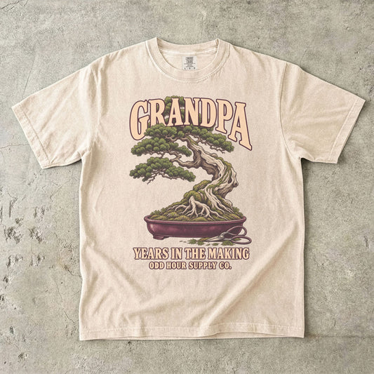Ivory-T-Shirt mit GRANDPA YEARS IN THE MAKING, Bonsai, sichtbaren Wurzeln und kleiner Schere von Odd Hour Supply Co.