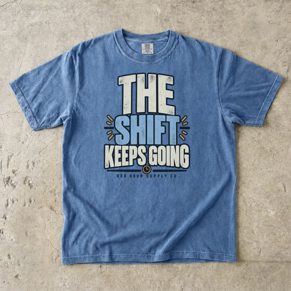 The Shift Keeps Going Typografie auf einem Comfort Colors T-Shirt in Washed Denim